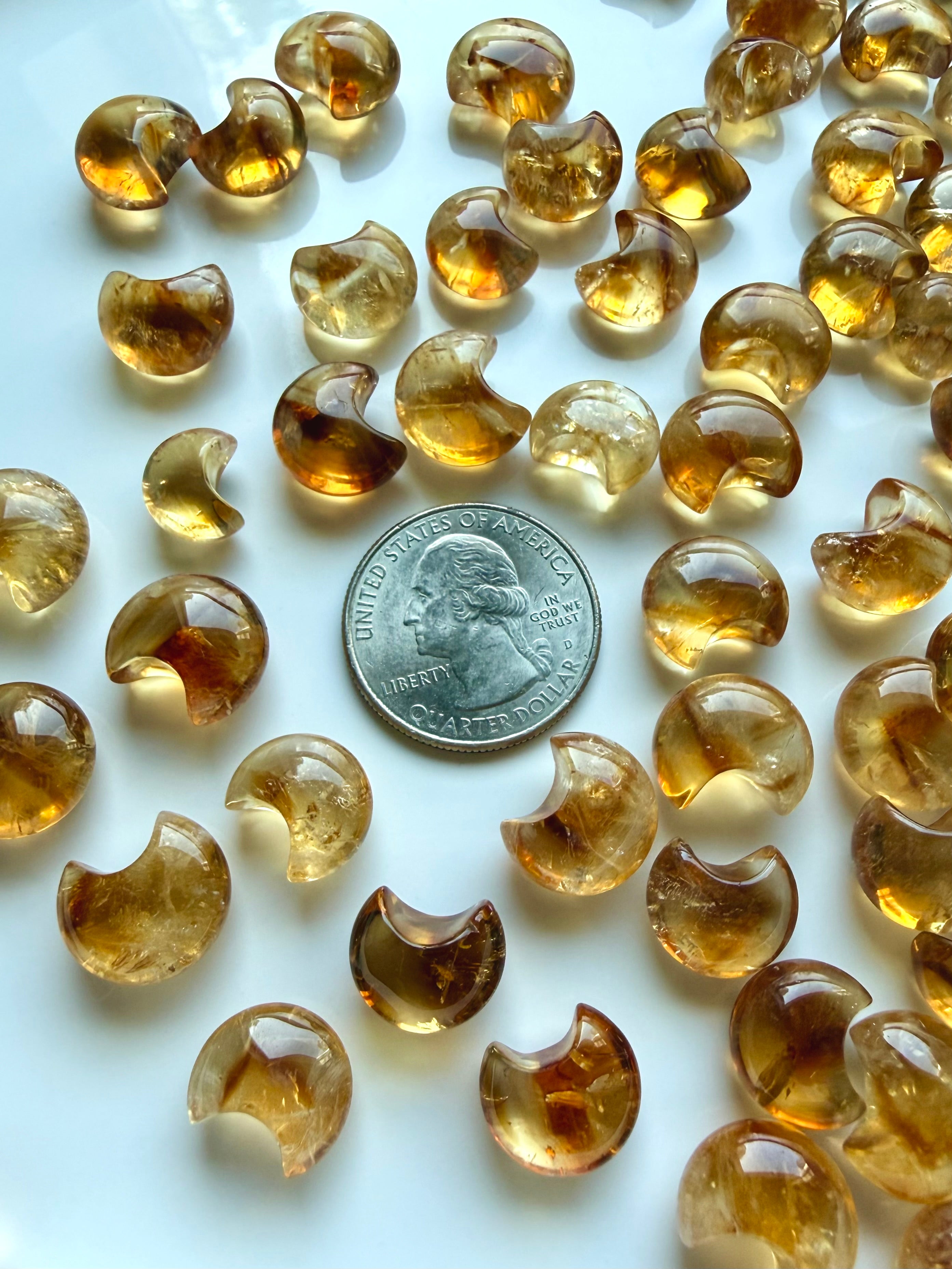 Mini Citrine moons shown with a US quarter for scale, highlighting their petite size and golden amber tones