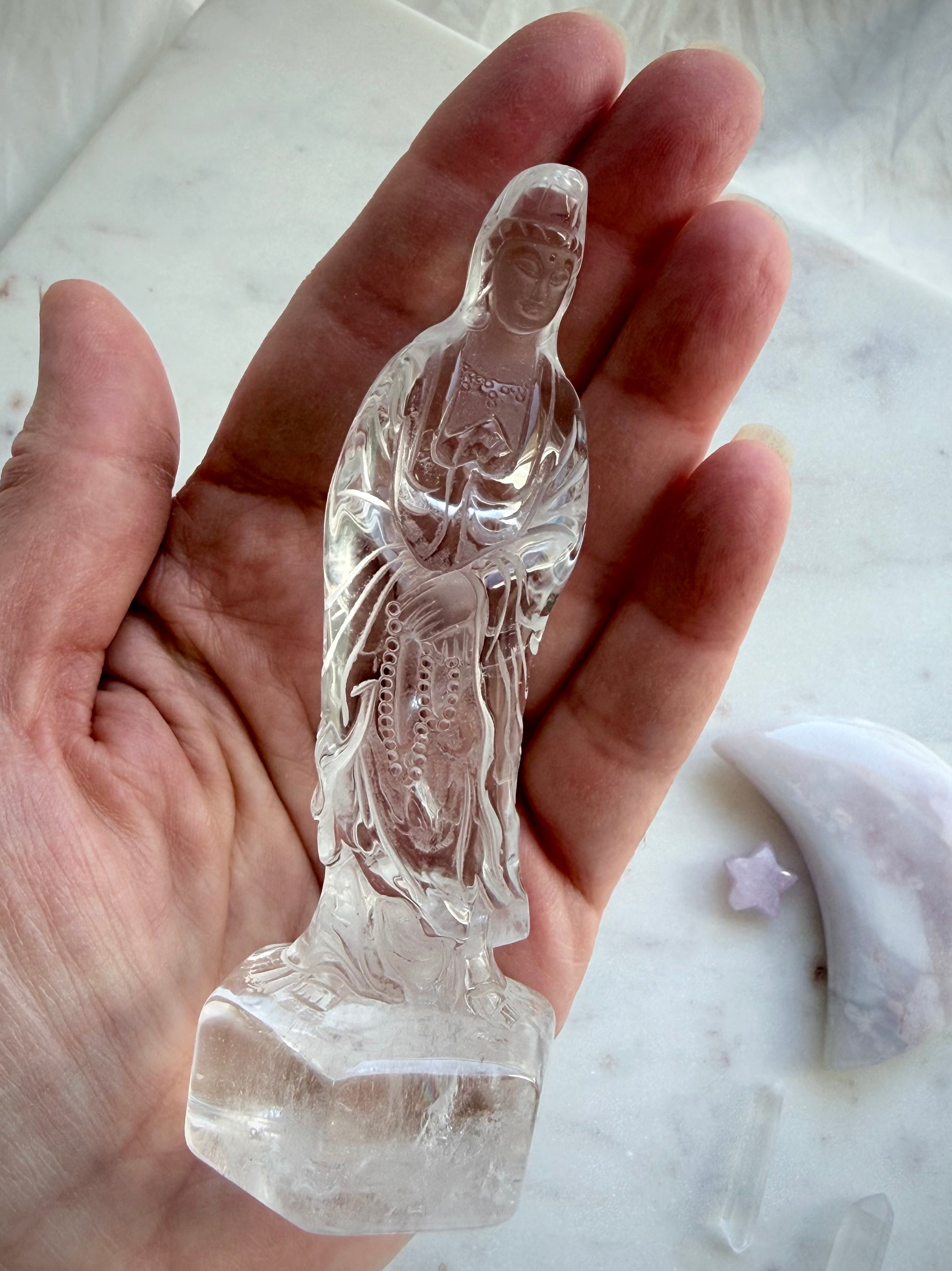 Clear Quartz Quan Yin statue held in the hand showing beautiful clarity and detailed craftsmanship