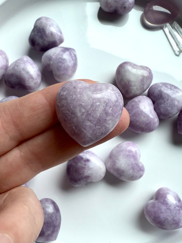 Calming Lepidolite puffy hearts shown on my fingertip for scale