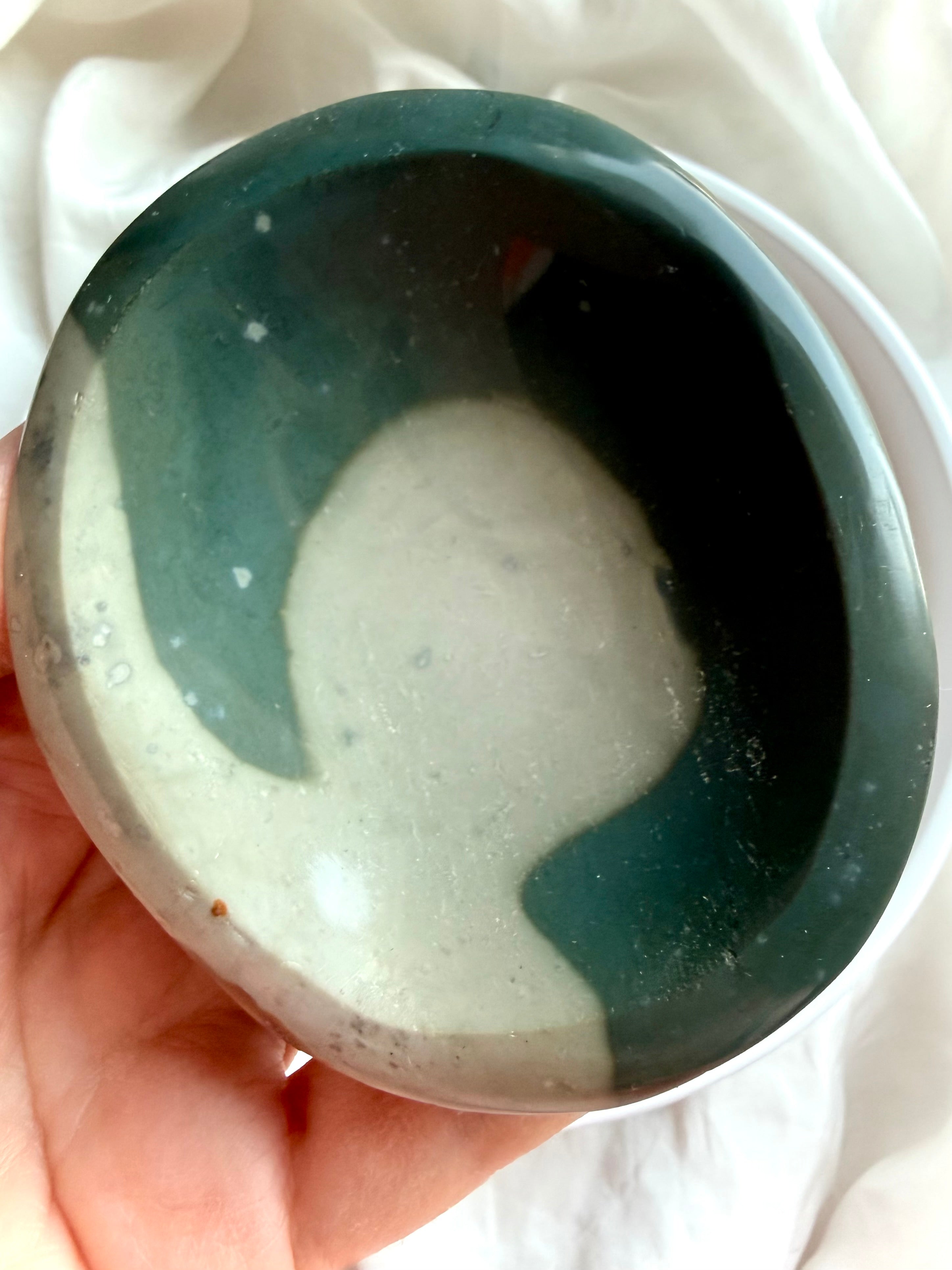 close up of a polychrome jasper bowl in hand showing size and smooth polished shallow shape