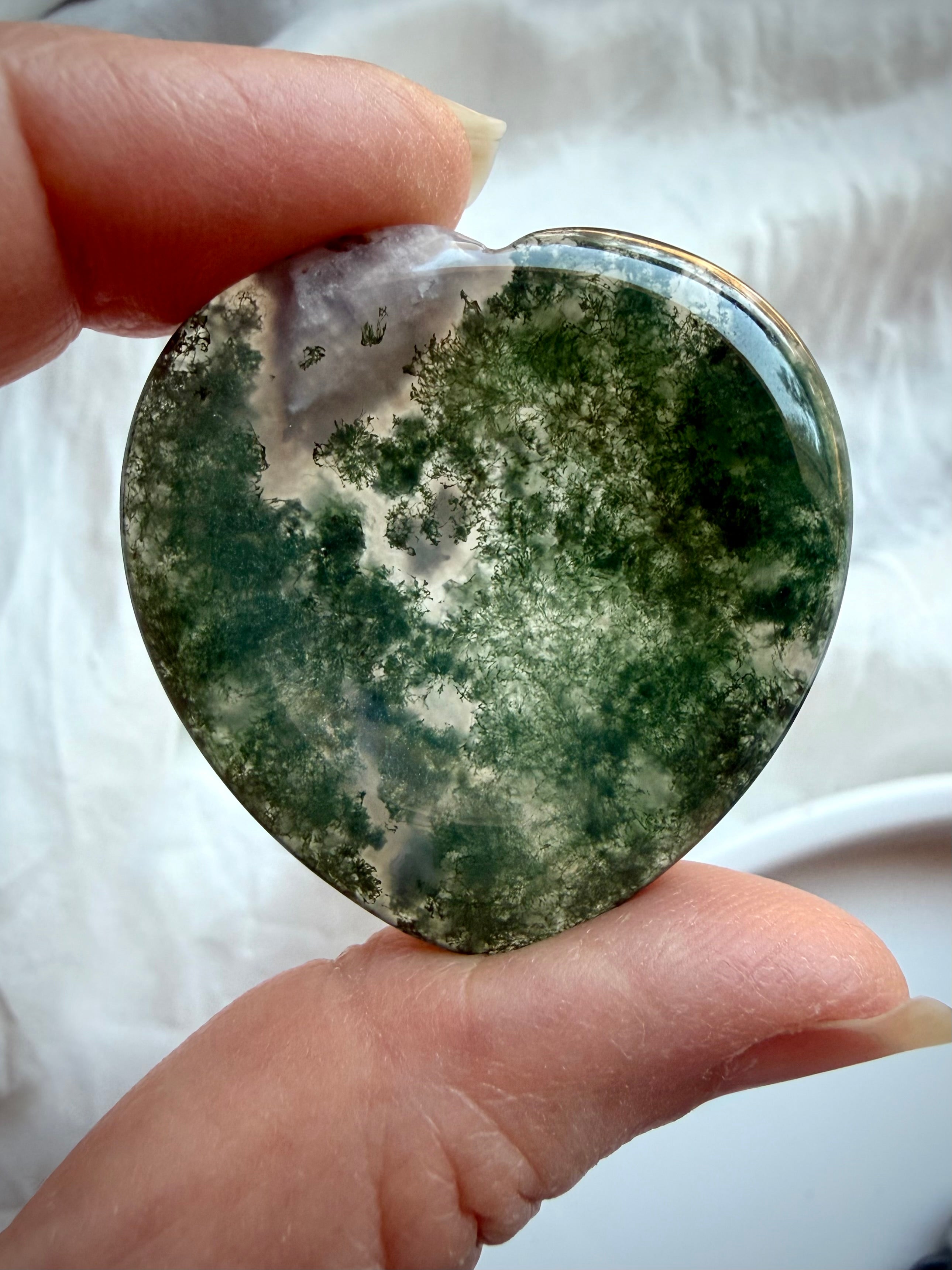 Polished Moss Agate heart worry stones showing natural variation in green inclusions and clear quartz