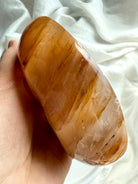Angled view of polished Golden Healer crystal offering bowl showing depth, glow, and natural stone patterns