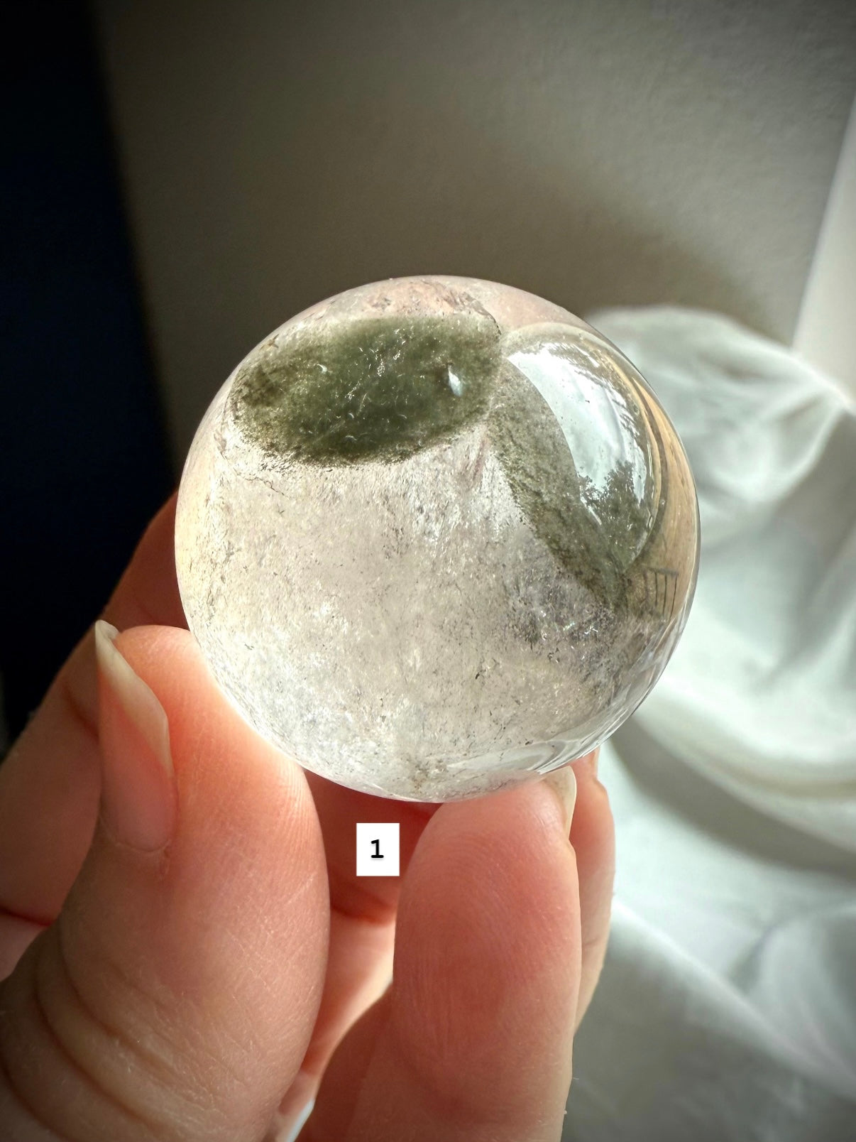 close-up of garden quartz sphere – clear crystal with moss-like inclusions for spiritual growth