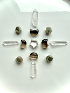 Celestial crystal grid with Smoky Quartz moons, Clear Quartz points and star, and geometric Pyrite crystals