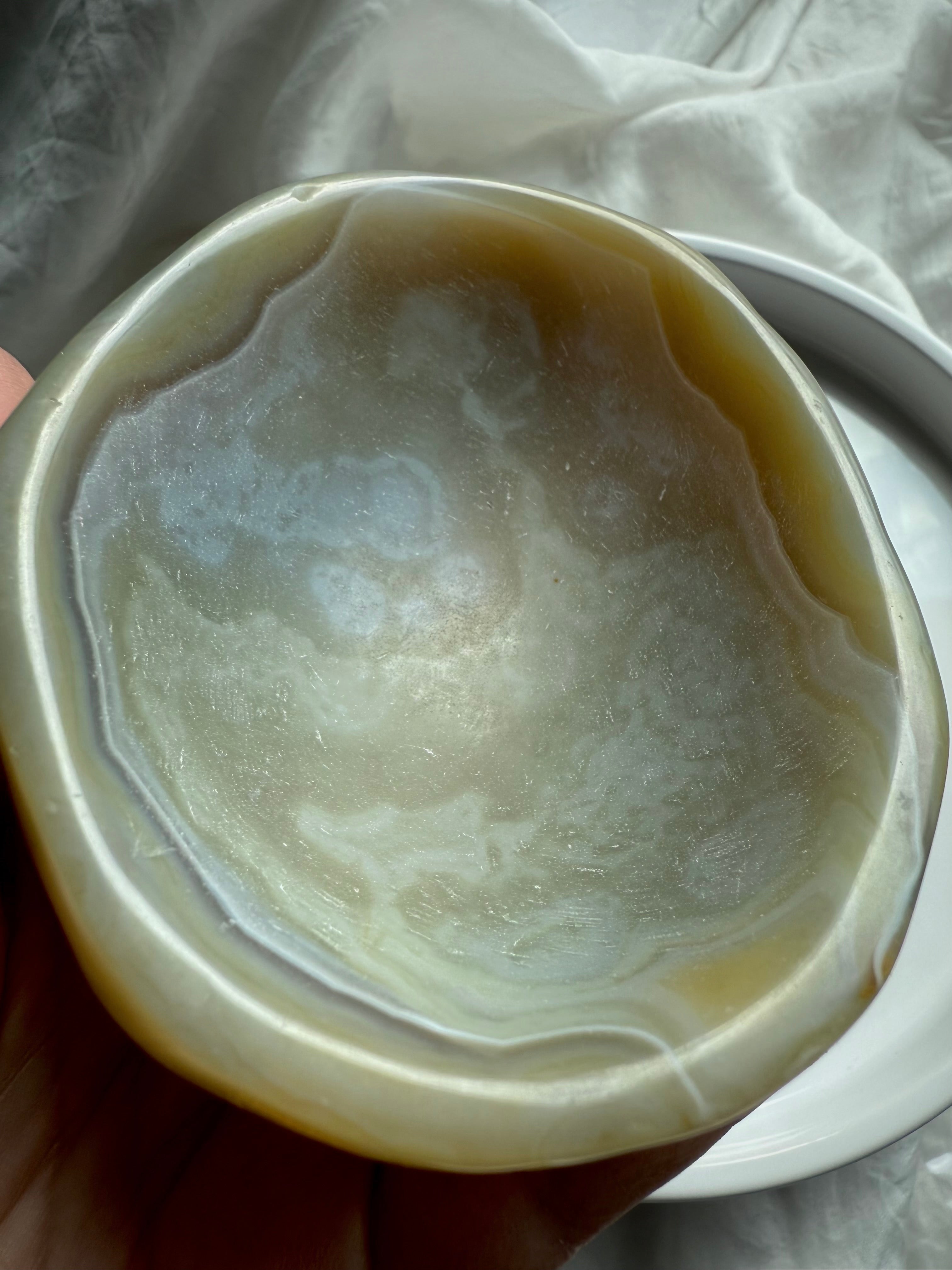 Close-up of beige agate crystal bowl showing polished banding and natural patterns – grounding gemstone dish