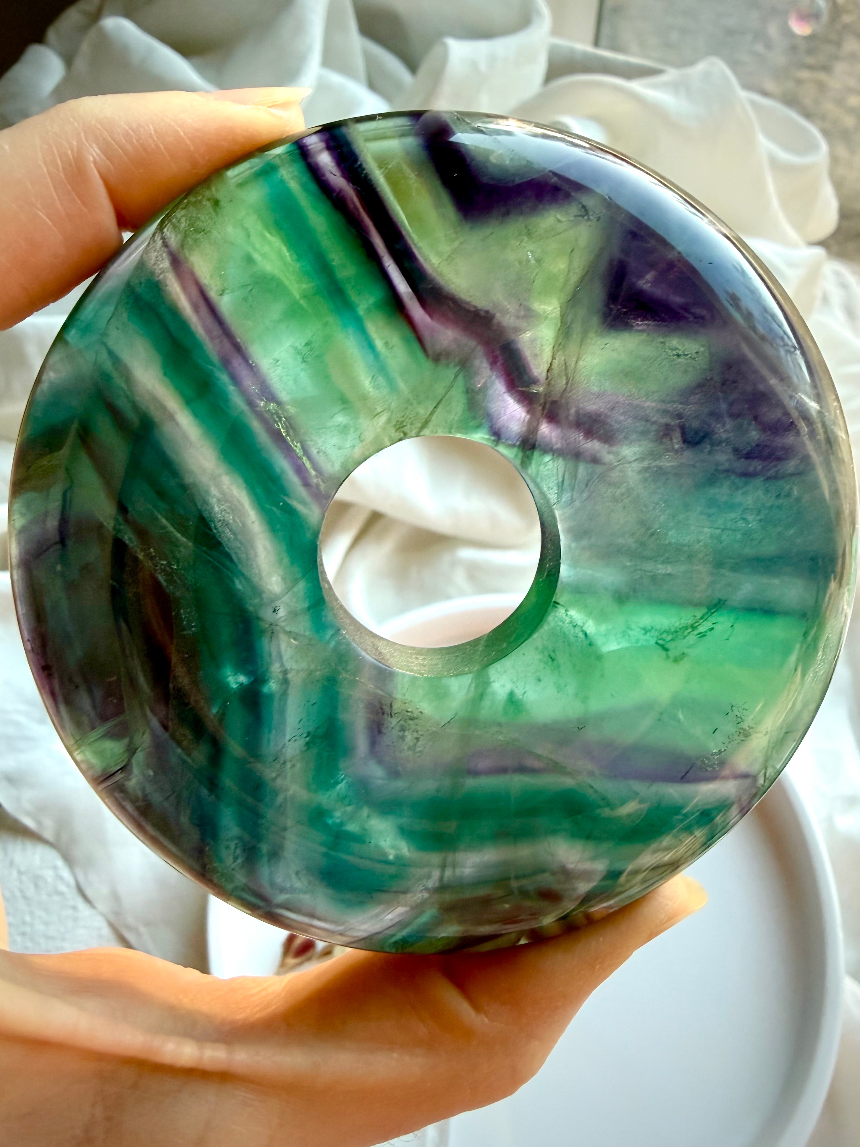 Close up of rainbow fluorite donut crystal peace buckle with glossy polish