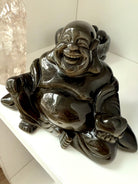 Golden Sheen Obsidian Happy Buddha displayed with pink Lemurian Quartz tower, perfect for altar decor or sacred space