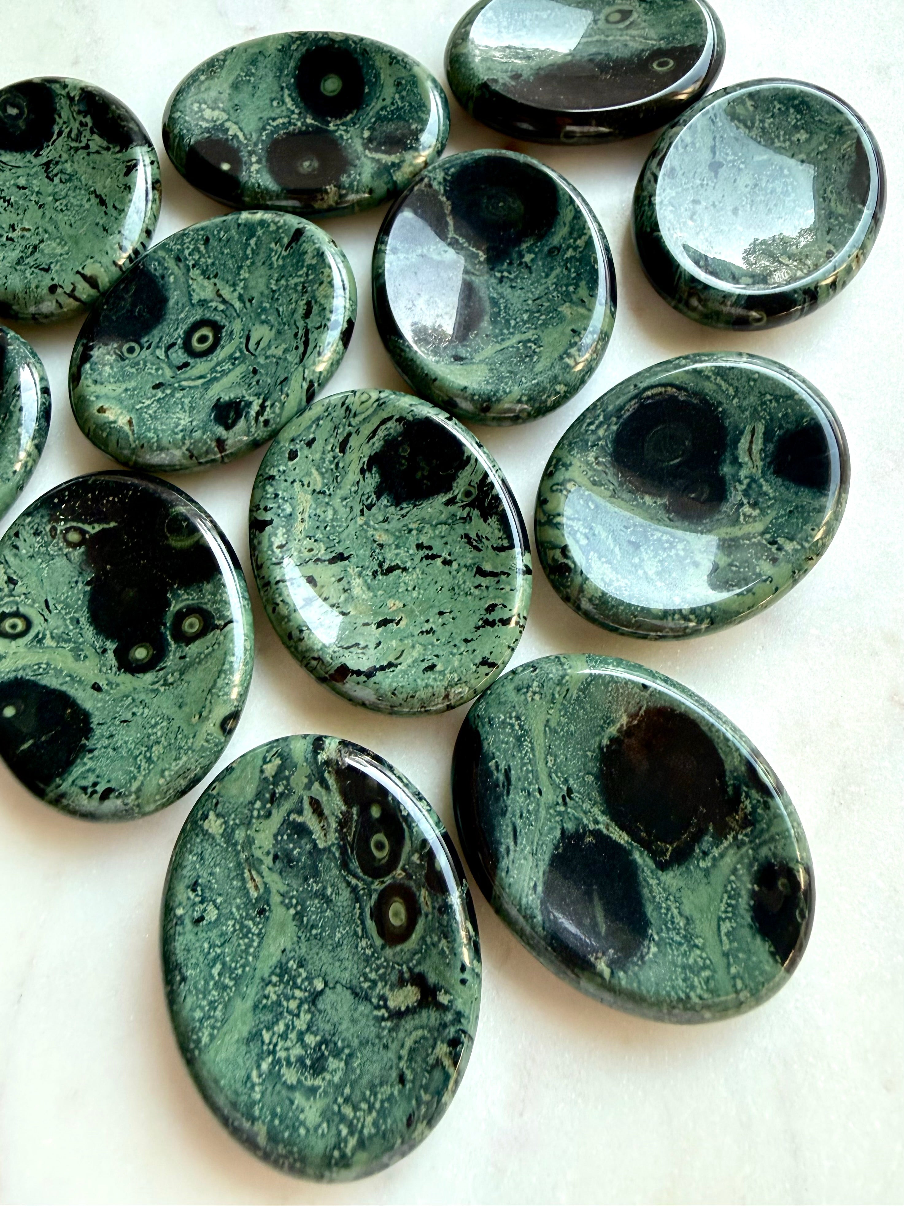 Kambaba Jasper worry stones with naturally varied green, teal, and black patterns, polished grounding stones for meditation