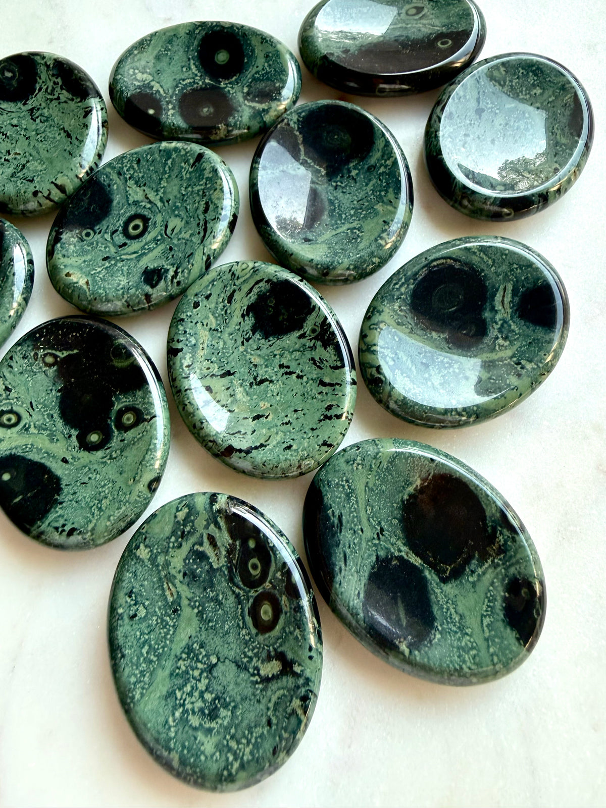 Kambaba Jasper worry stones with naturally varied green, teal, and black patterns, polished grounding stones for meditation