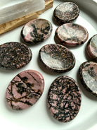 Natural Rhodonite worry stones with varied spiderweb and dendritic veining