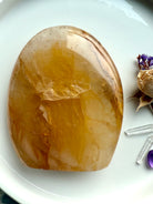 Flatlay of polished Golden Healer Quartz freeform with radiant golden color & luminous healing energy