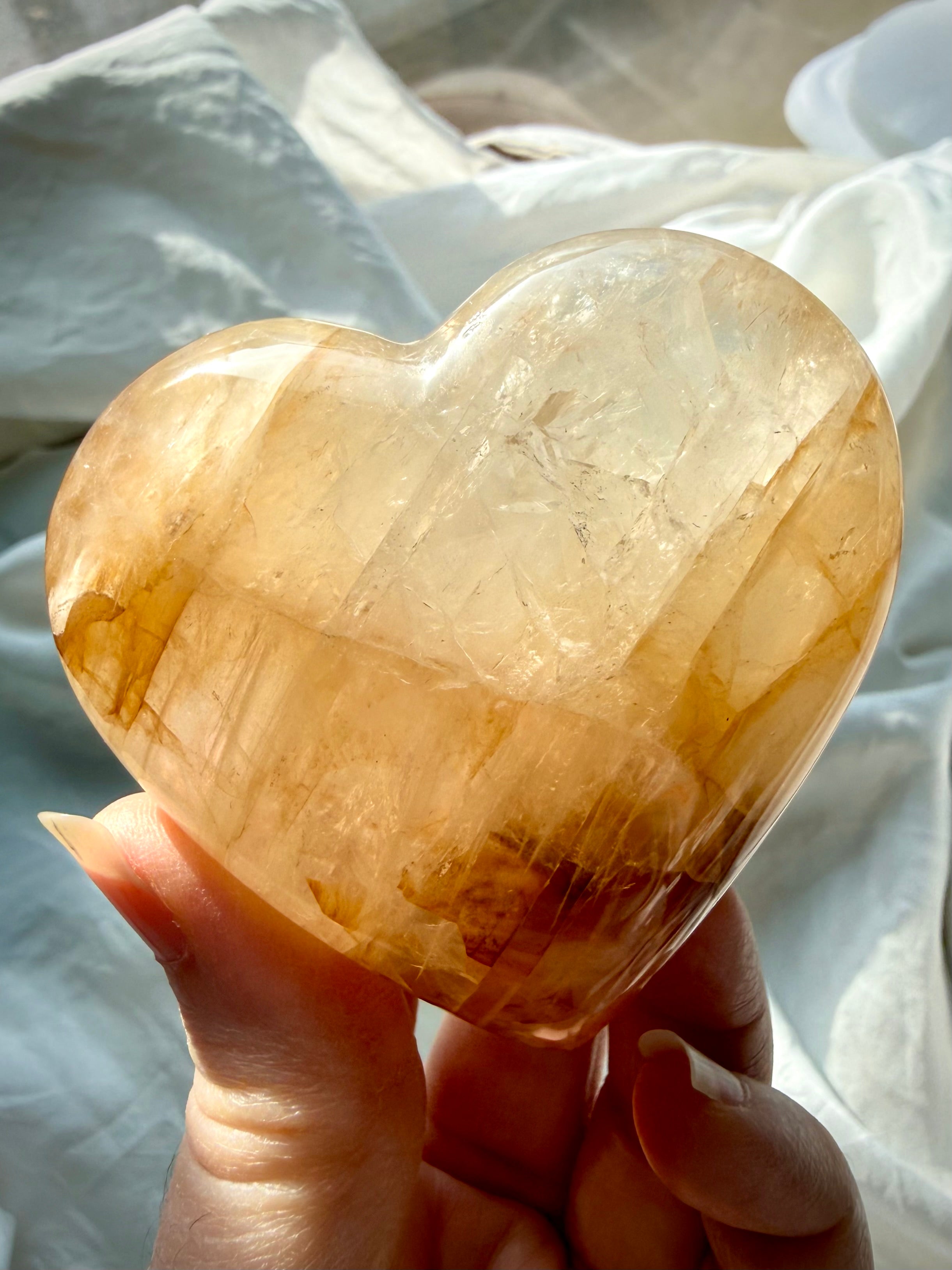 Close up of one of a kind Golden Healer quartz heart displaying golden inclusions and luminous clarity