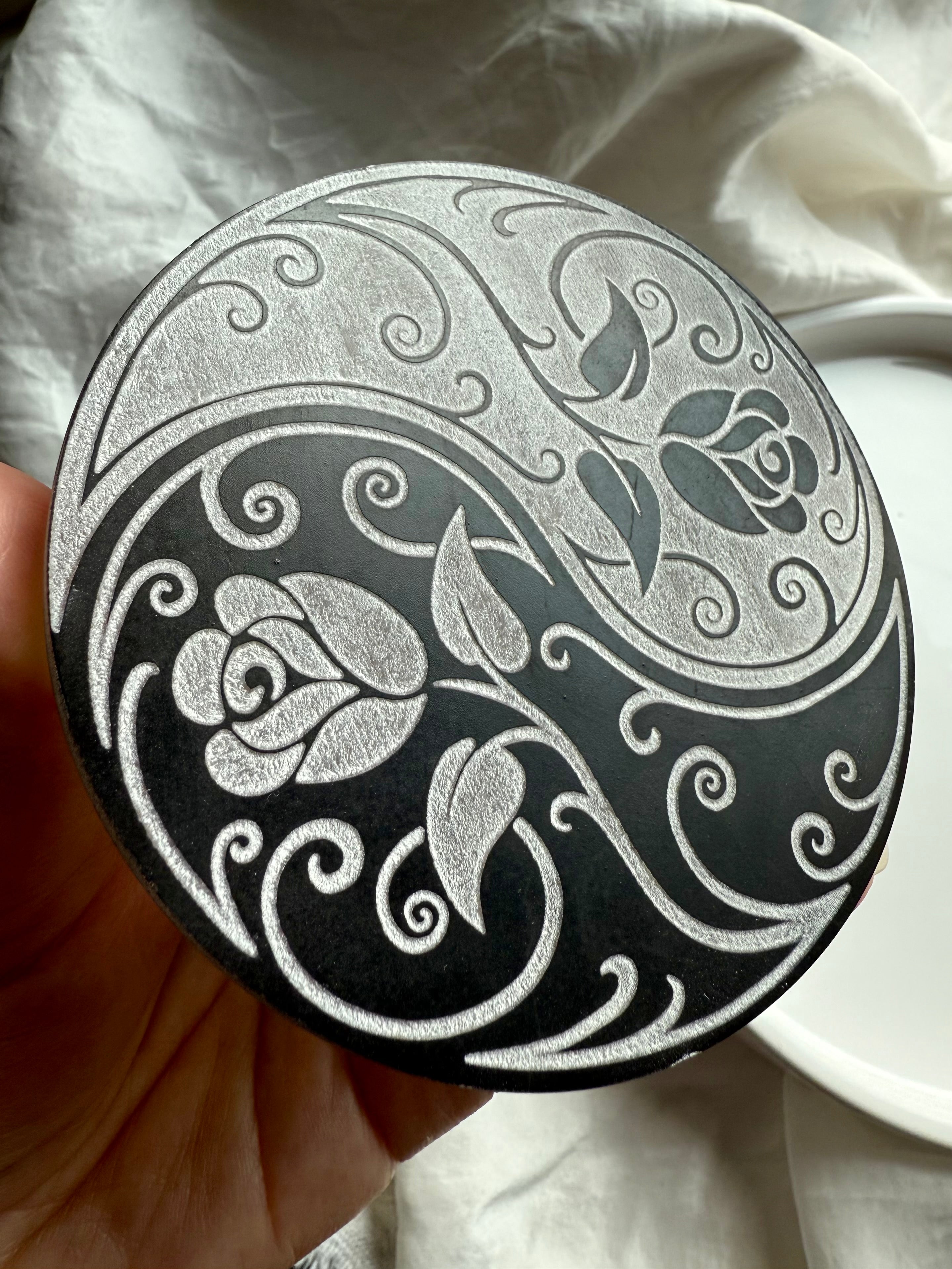 Closeup of selenite yin yang rose plate with detailed floral etching for energy cleansing and grounding rituals