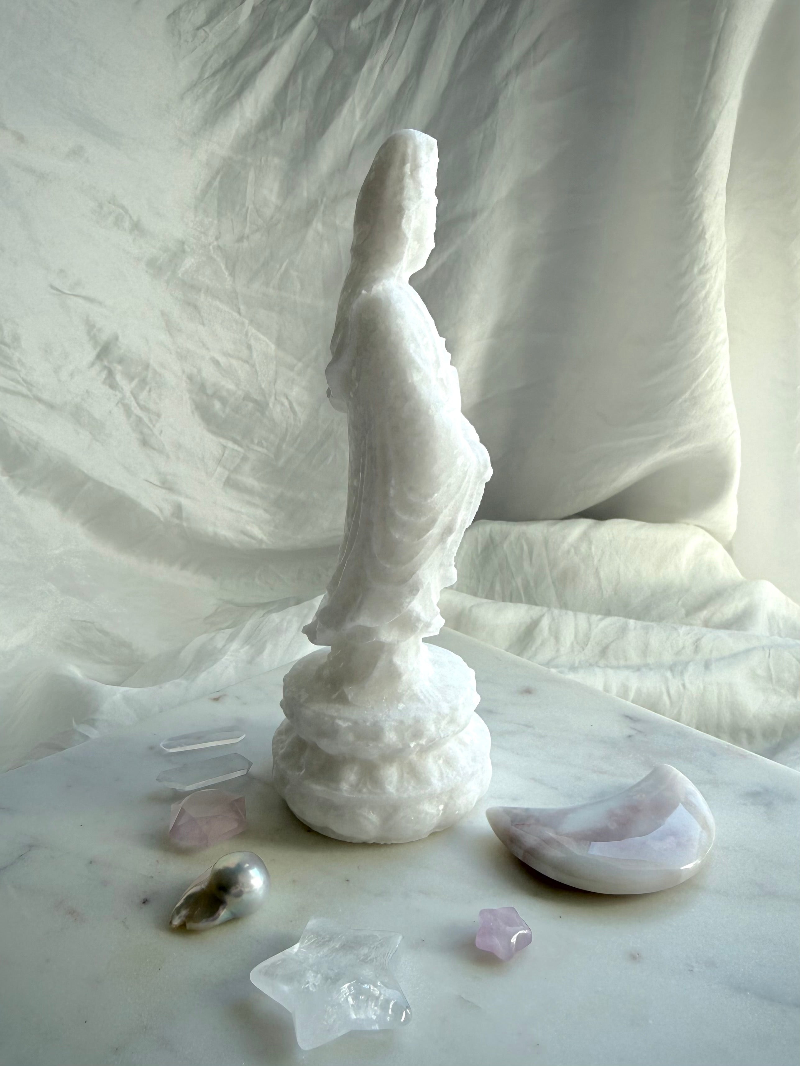 Three-quarter view of White Jade Goddess carving with soft matte finish and natural translucency