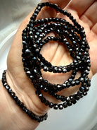 stacked black spinel bracelets on hand for grounding protection and everyday wear