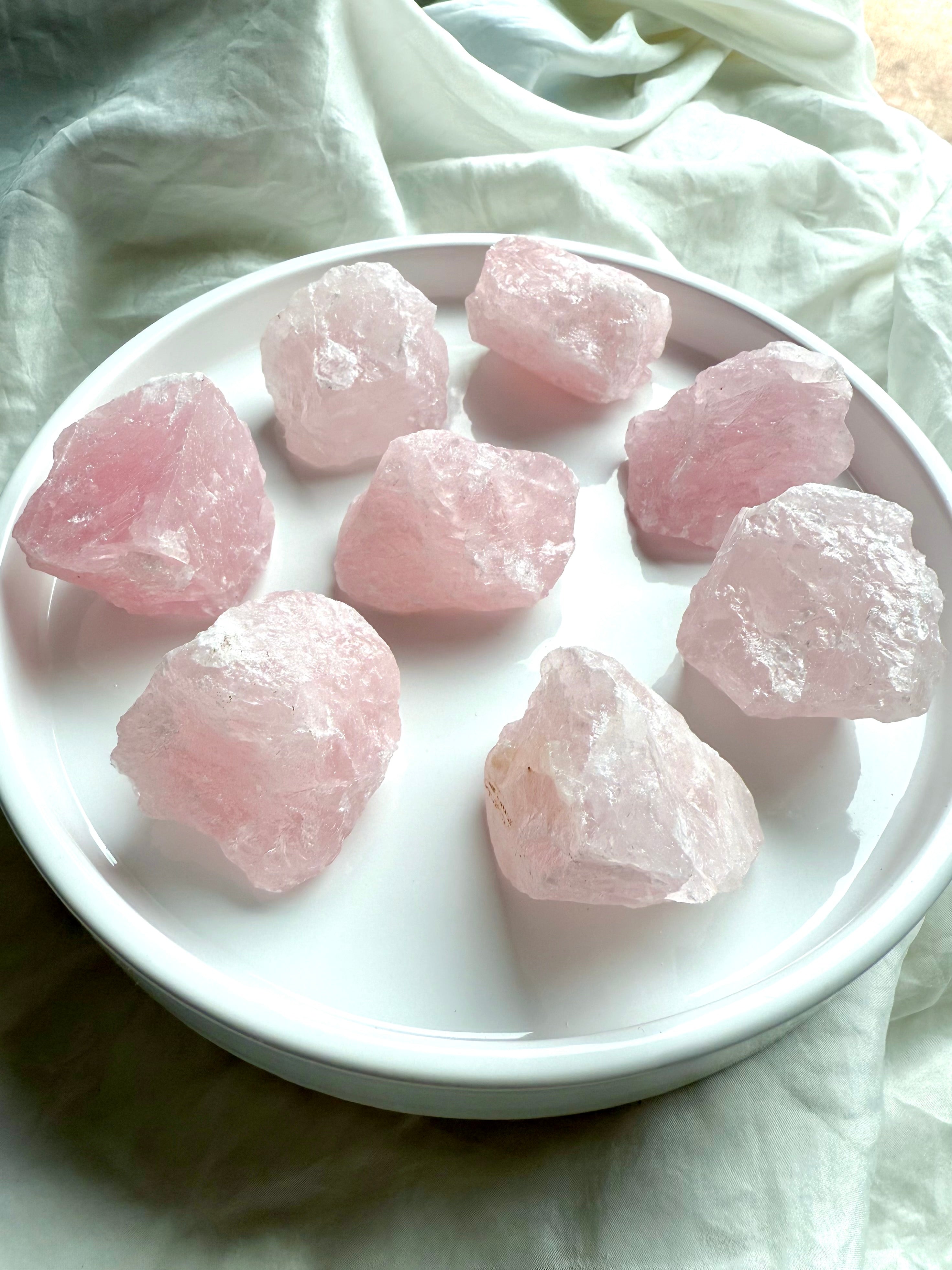 Large raw Rose Quartz crystal chunks from Madagascar on white. Pink stones for Heart chakra healing.