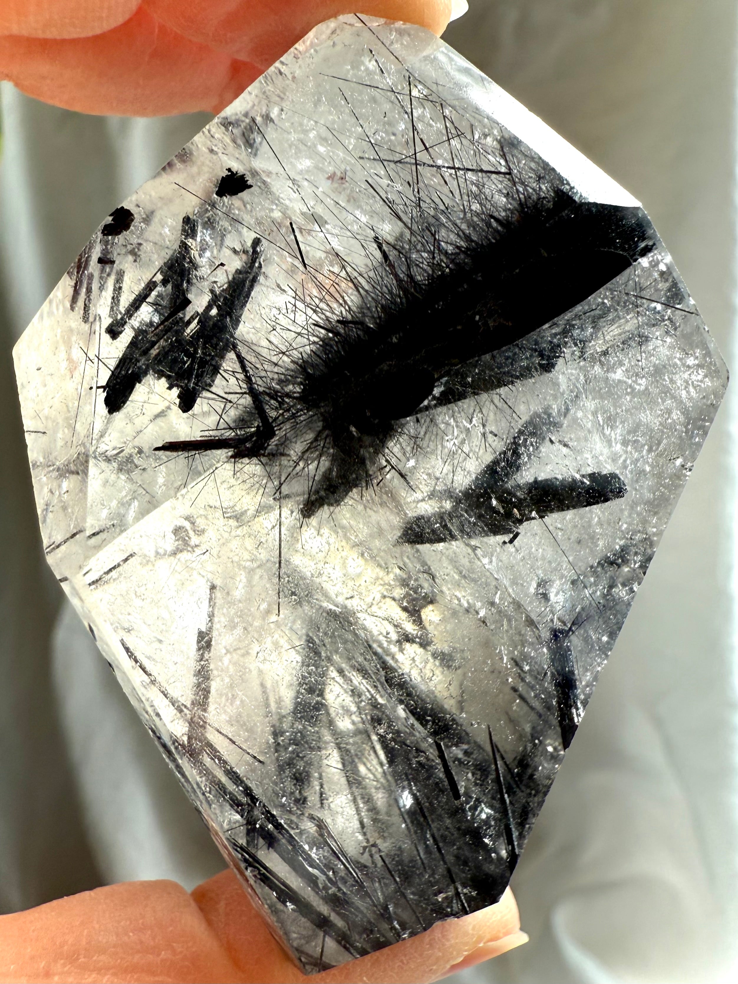 Black Tourmaline in Quartz freeform crystal held in hand, powerful protection stone with dense black tourmaline needle inclusions in clear quartz