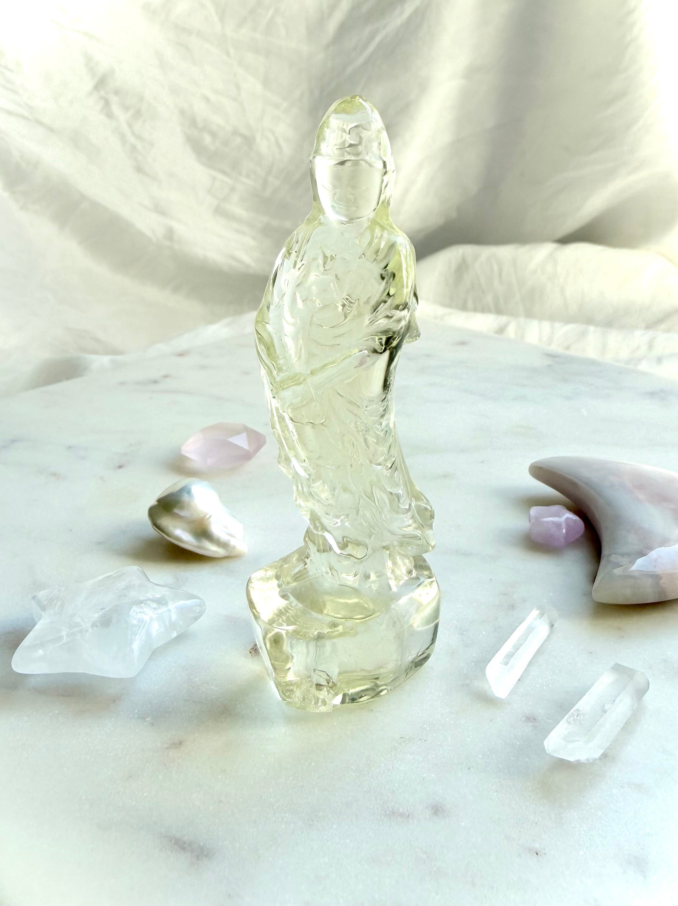 Citrine Quan Yin statue arranged in an altar display with clear quartz points, pearls, and crystal moons for abundance and positivity