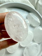 Clear Quartz crystal palm stone held in hand with translucent layers, silvery flashes and natural internal veiling