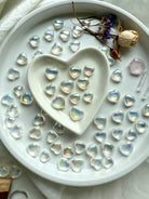 Aura quartz hearts with rose, statice, Lemurian points, and pink faceted gem in a heart bowl altar setup