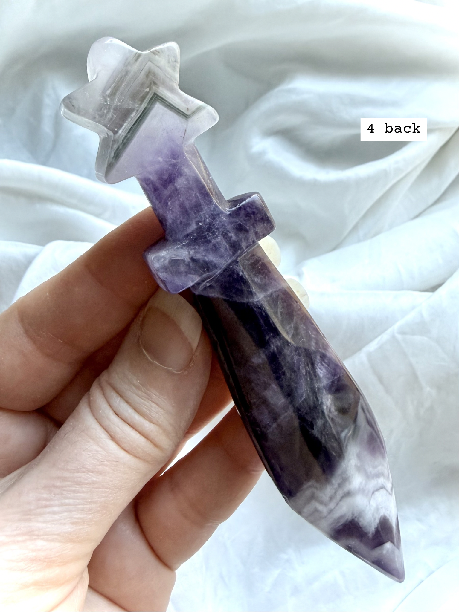 Reverse side of Dream Amethyst crystal dagger carving with layered lavender and white banding