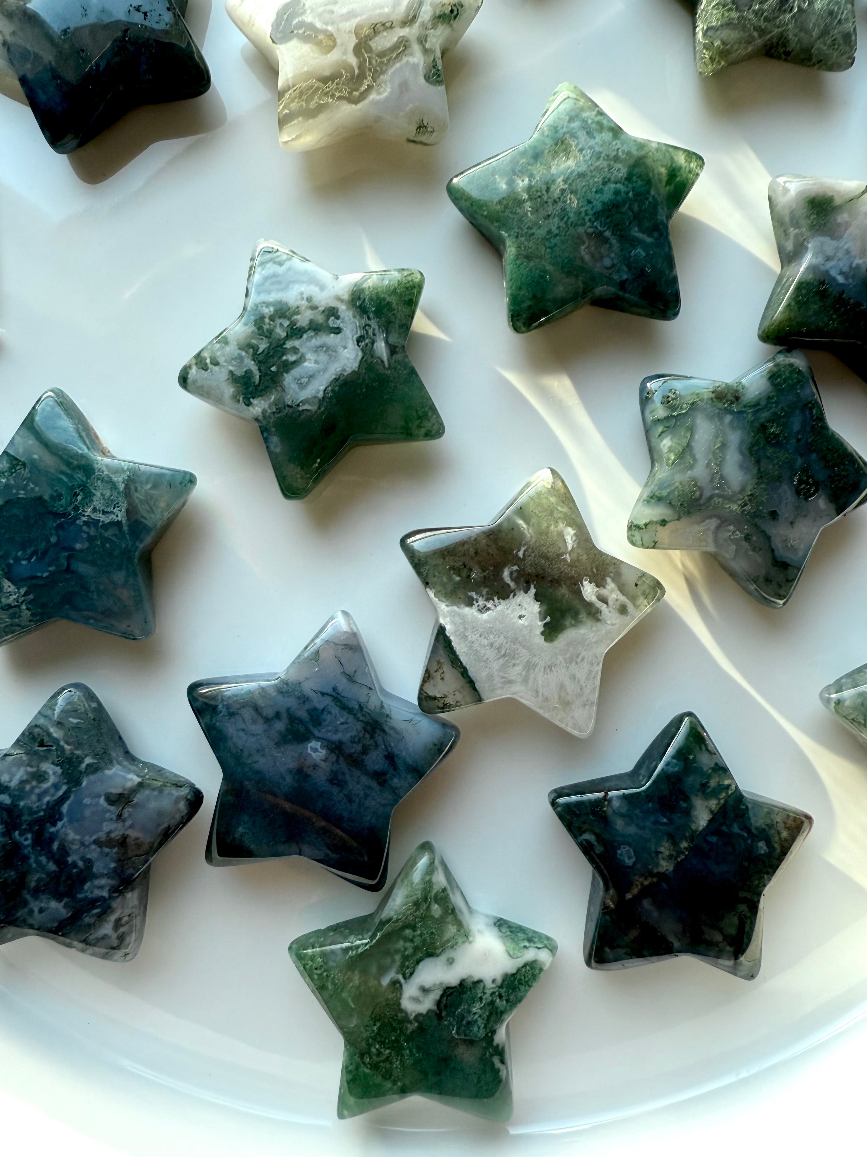 moss agate star crystals with swirling green and white patterns photographed in natural light highlighting earthy heart-centered energy