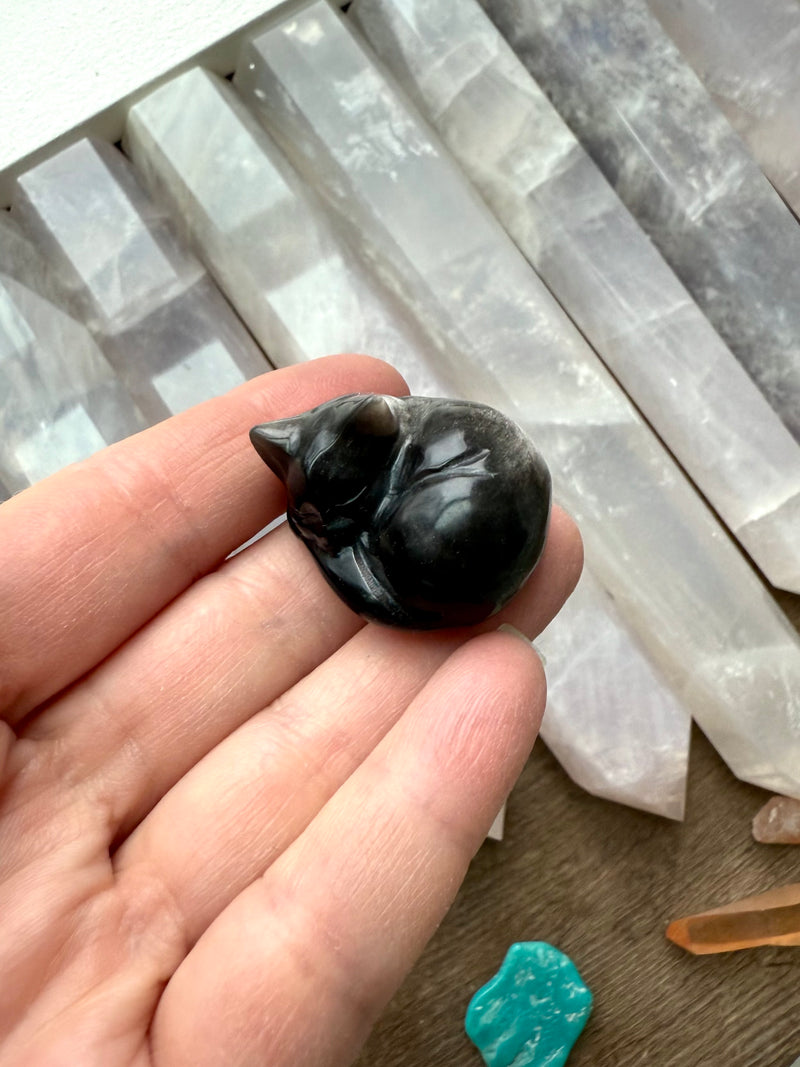 This tiny Silver Sheen Obsidian Sleeping Cat offers energetic protection to your sacred space. 