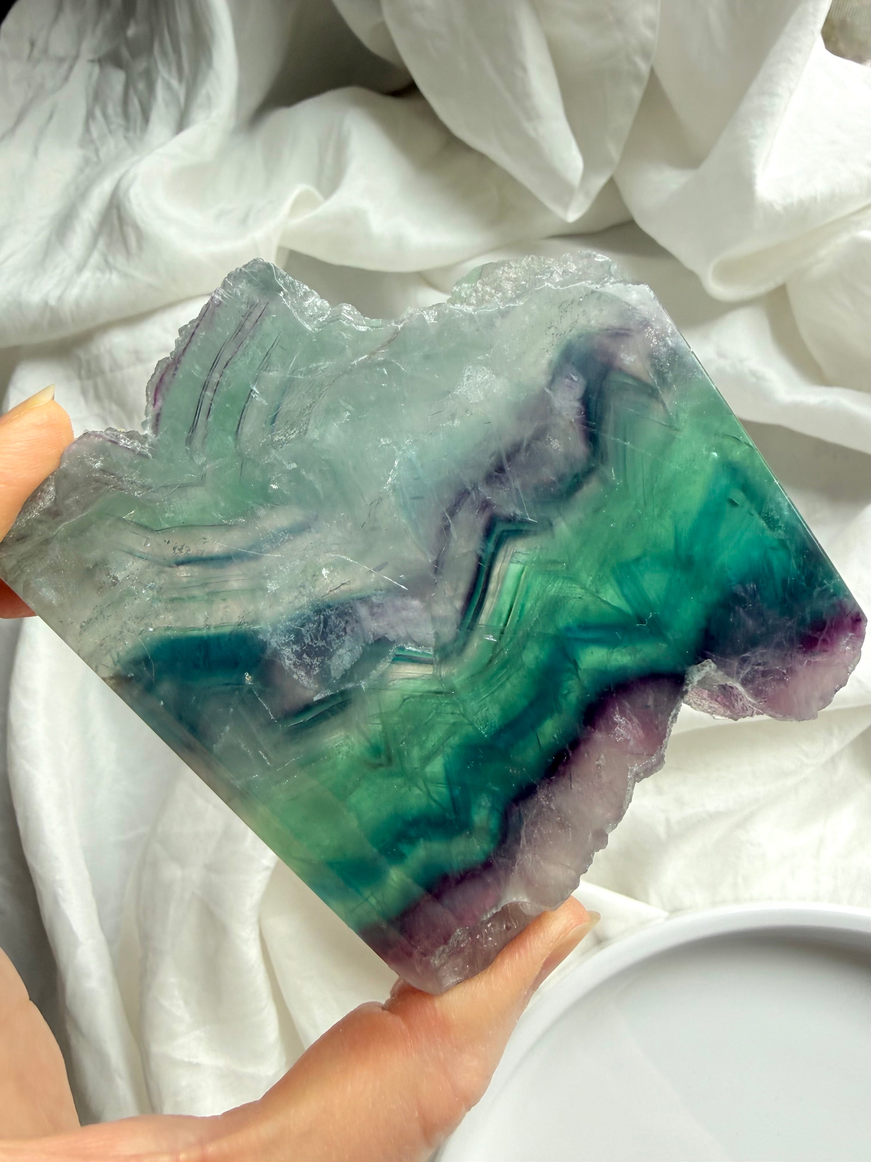 Polished fluorite slab photographed in natural light highlighting teal, green & purple crystal bands