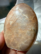 Peach Moonstone with Sunstone shimmer showing golden sparkle, silvery glow and rainbow flashes across the polished crystal