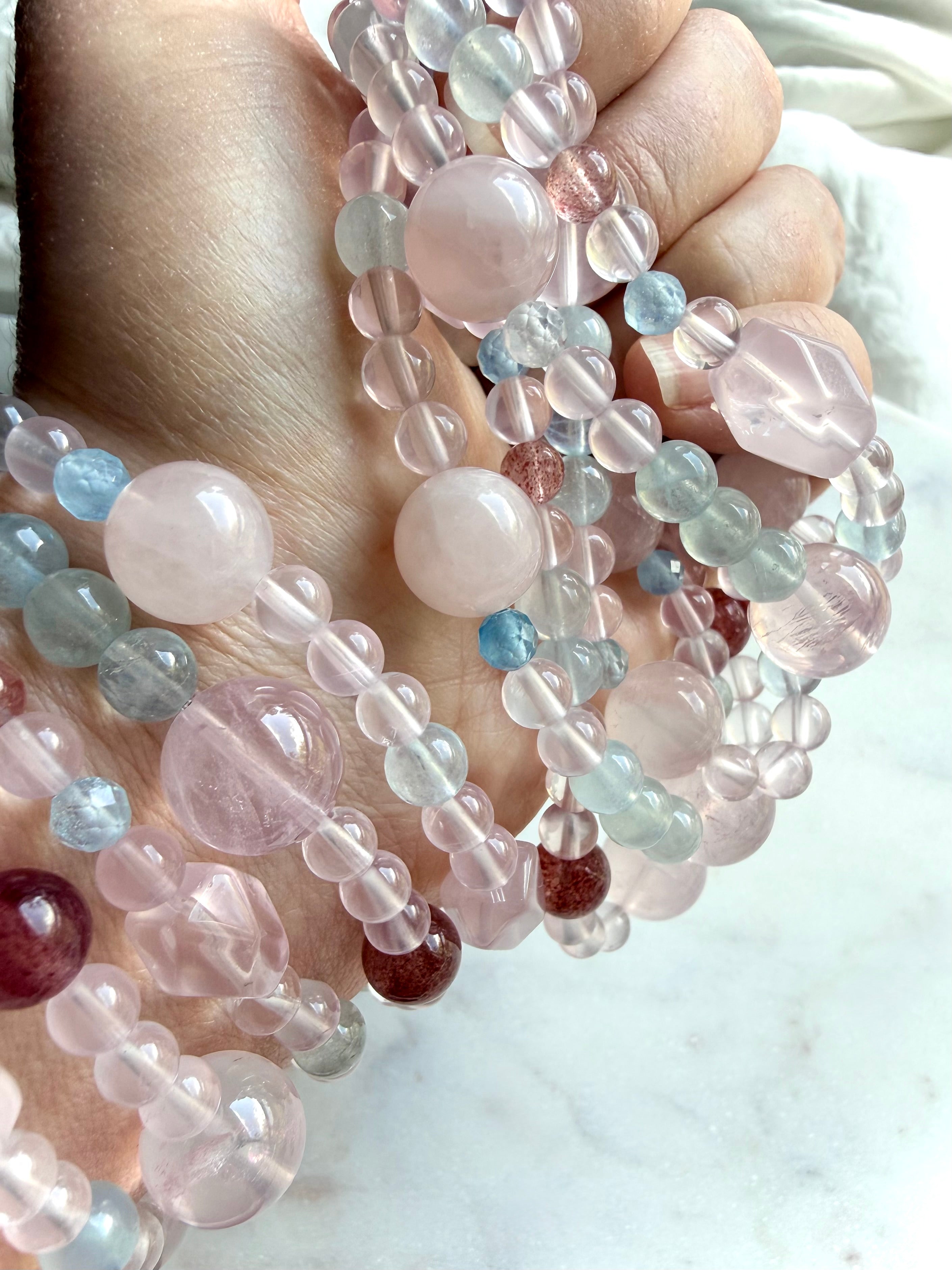 pastel mixed gemstone bracelet close-up with rose quartz focal bead and aquamarine accents, heart chakra crystal bracelet with natural variation