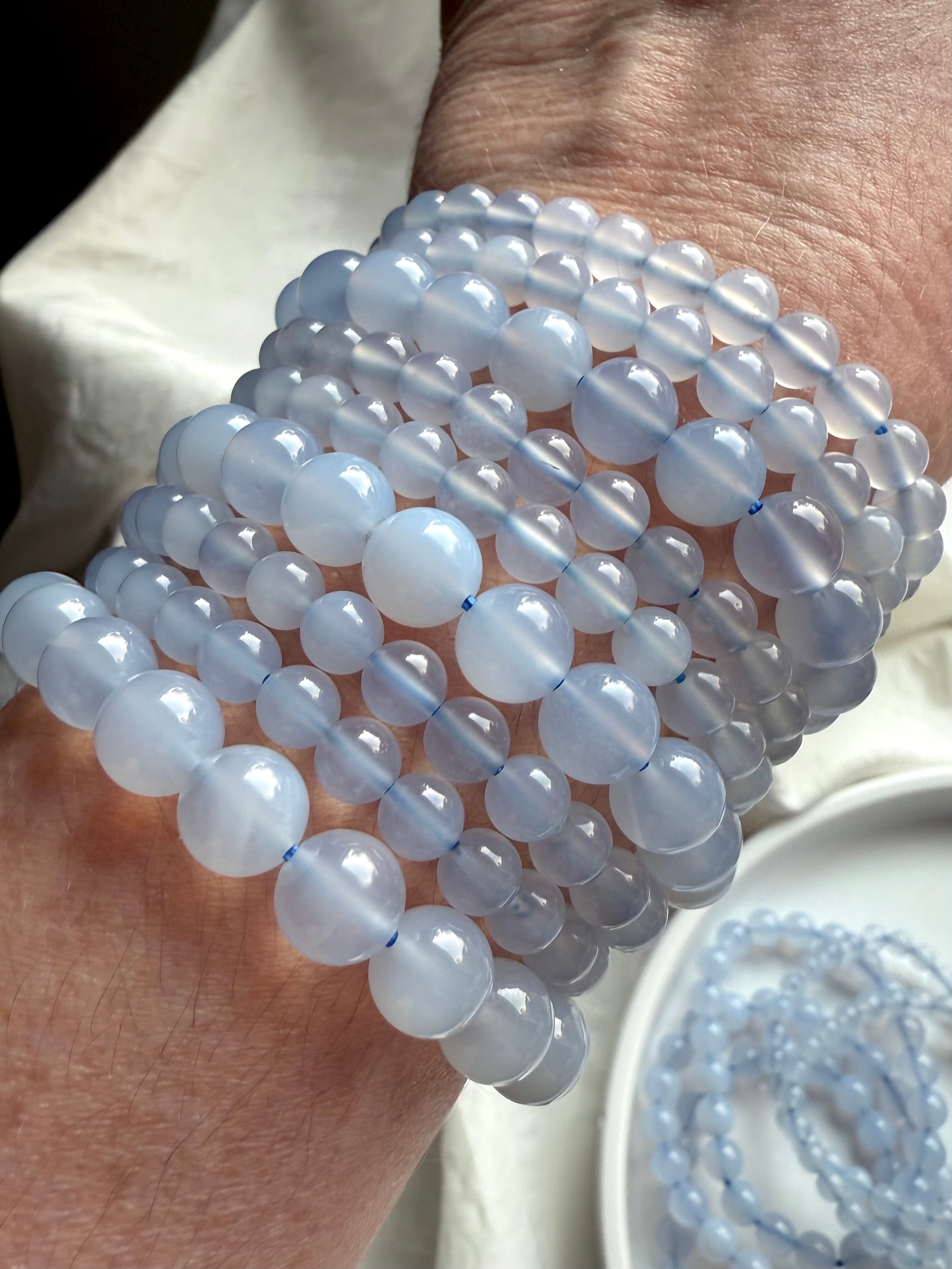 Light blue Blue Chalcedony bracelet beads on wrist, reflecting soft light with ethereal translucence