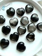 Silver Sheen Obsidian mini heart carvings on white for protection, grounding and energy clearing