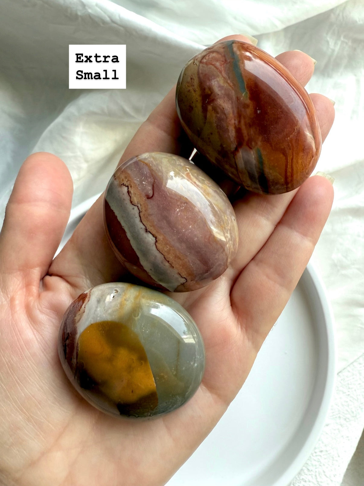 Extra small Polychrome Jasper palm stone shown in hand, perfect pocket stone for grounding & calm. 