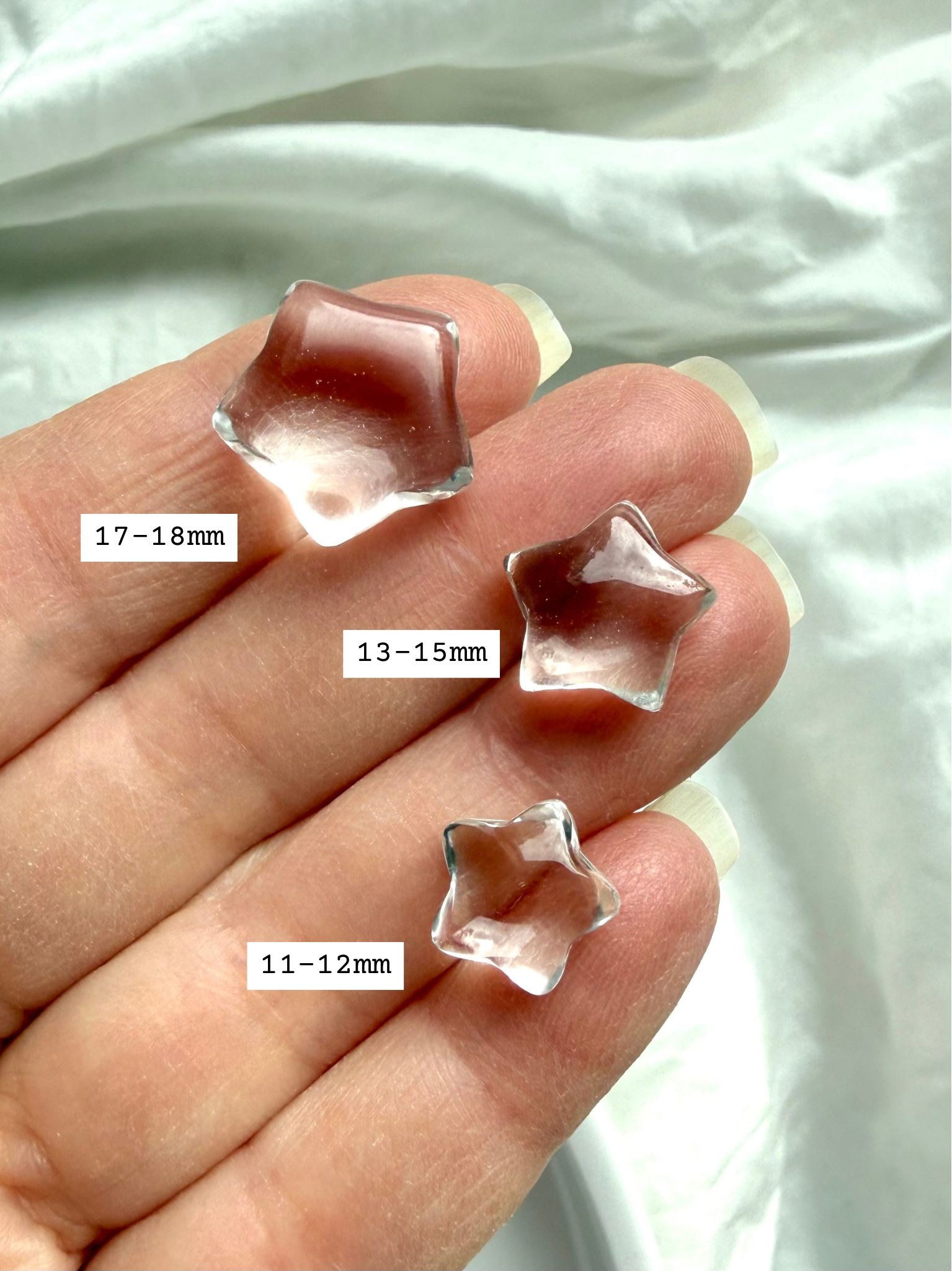 Mini Clear Quartz stars held in hand with size measurements, showing tiny polished crystal carvings for jewelry making and crystal grids