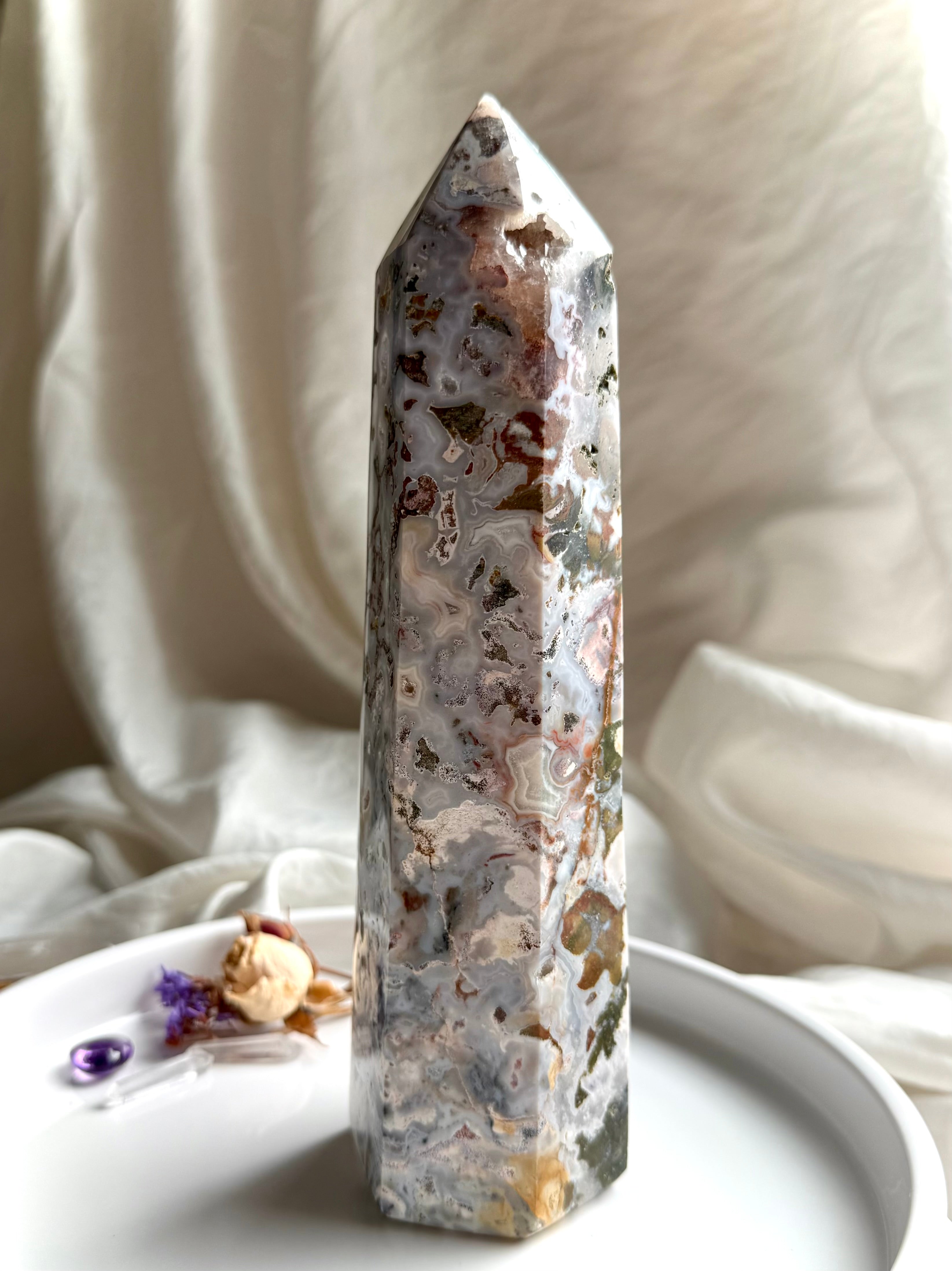 Standing Cosmic Ocean Jasper crystal point with polished faces, ocean-like patterns, and grounding earthy inclusions