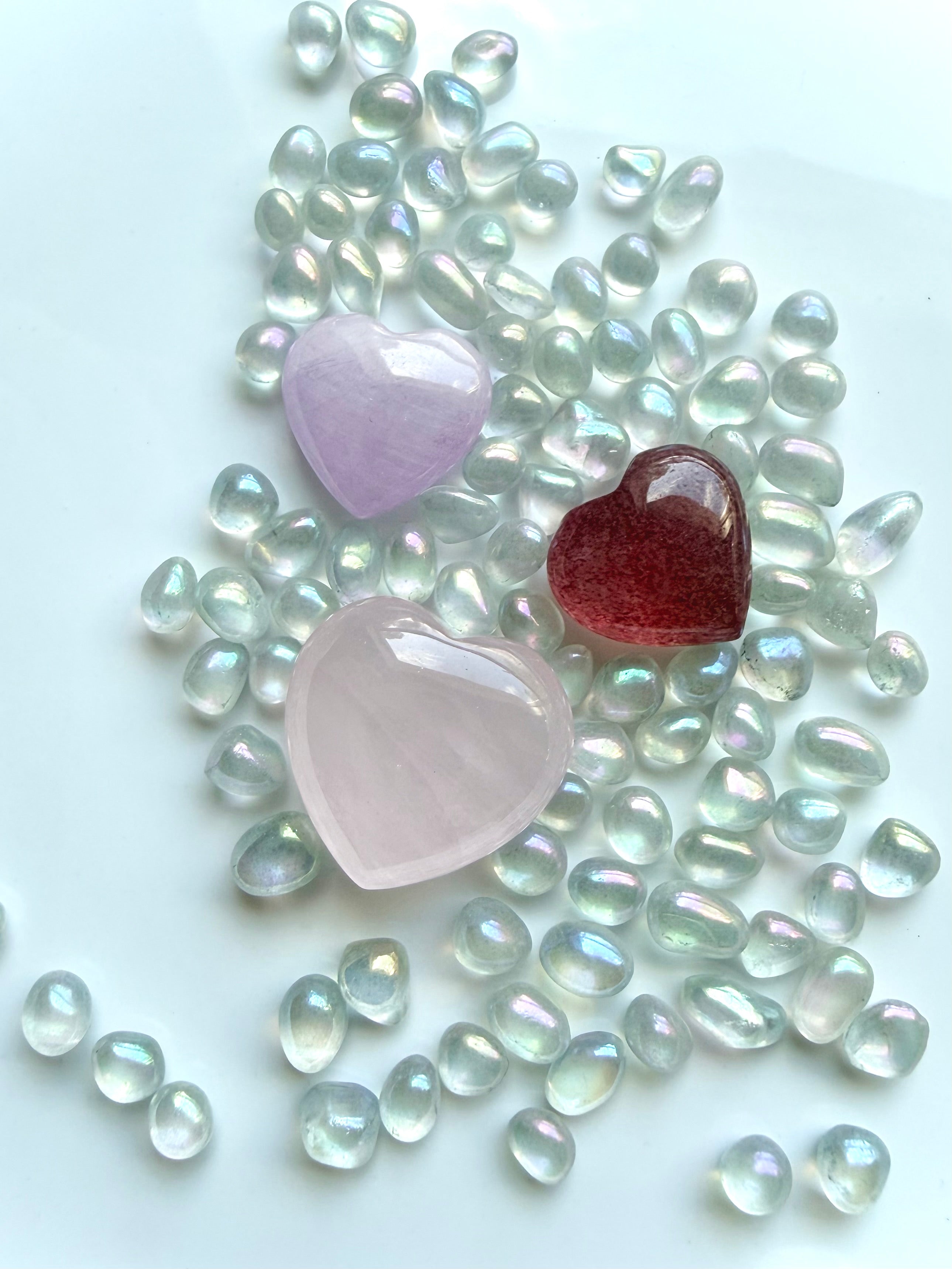 Three mini crystal hearts with aura crystal confetti including rose quartz, strawberry quartz, and kunzite healing stones
