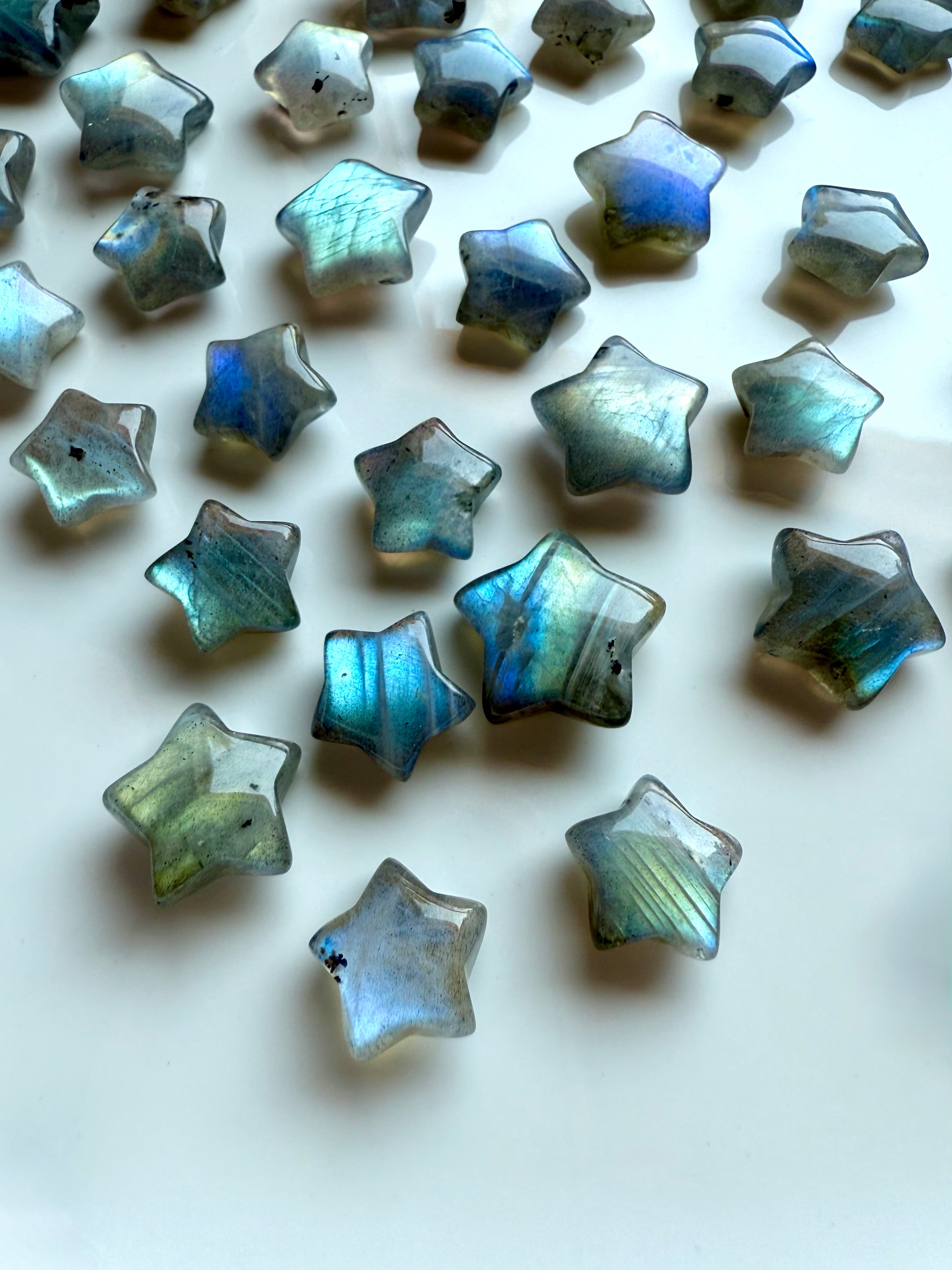 Wide angled view of pastel Labradorite mini stars showing flash, color &amp; texture — iridescent star carvings for chakra healing &amp; crystal décor.