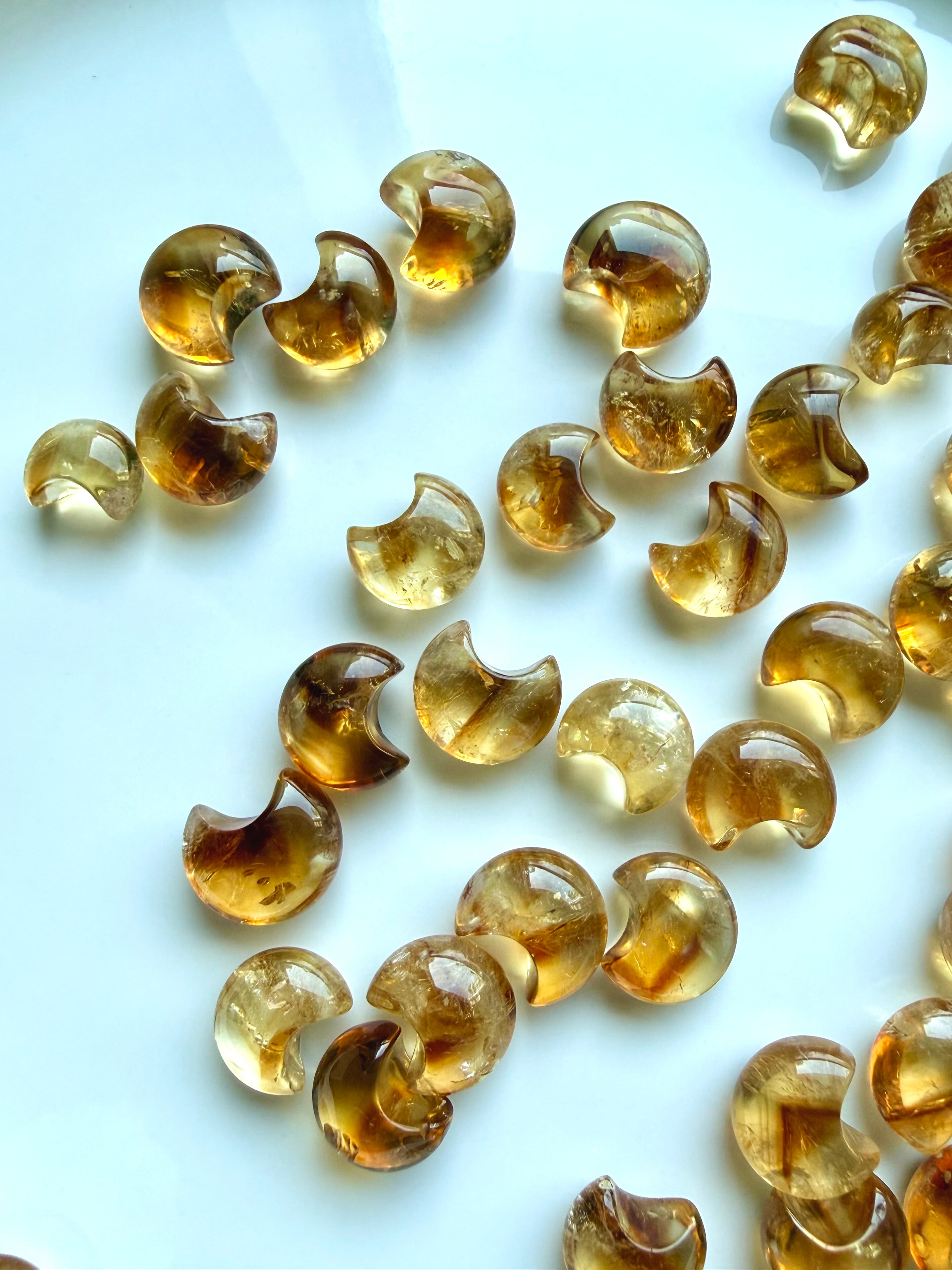 Mini Citrine moon carvings showing translucent golden honey tones, natural color zoning and inner dimension