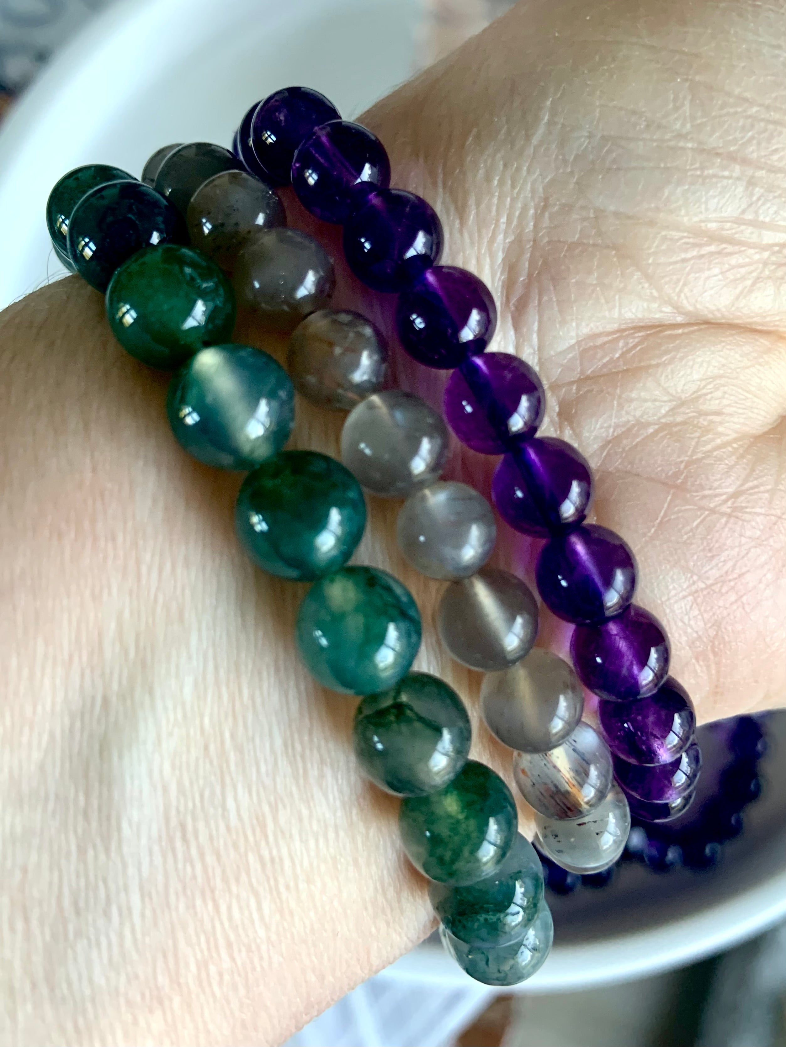 A combination of three healing crystal bracelets worn together