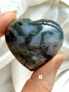 moss agate heart carving option 4 in hand with rich green inclusions and natural landscape pattern