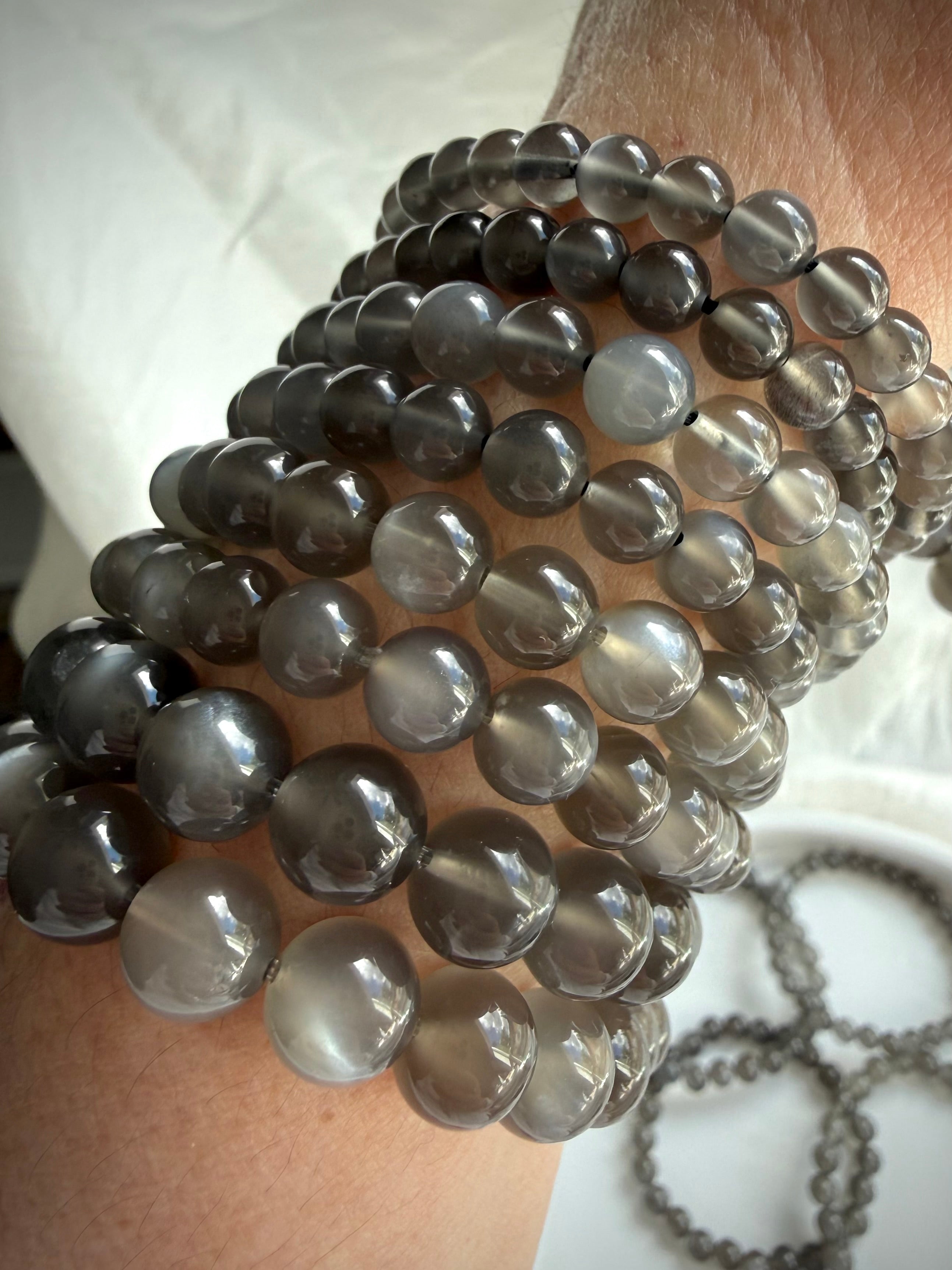 Black Moonstone bracelets worn on wrist showcasing silky moonlit shimmer and translucent charcoal gray gemstone beads