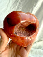 Side view of large Carnelian geode heart highlighting sparkling druzy crystal cavity