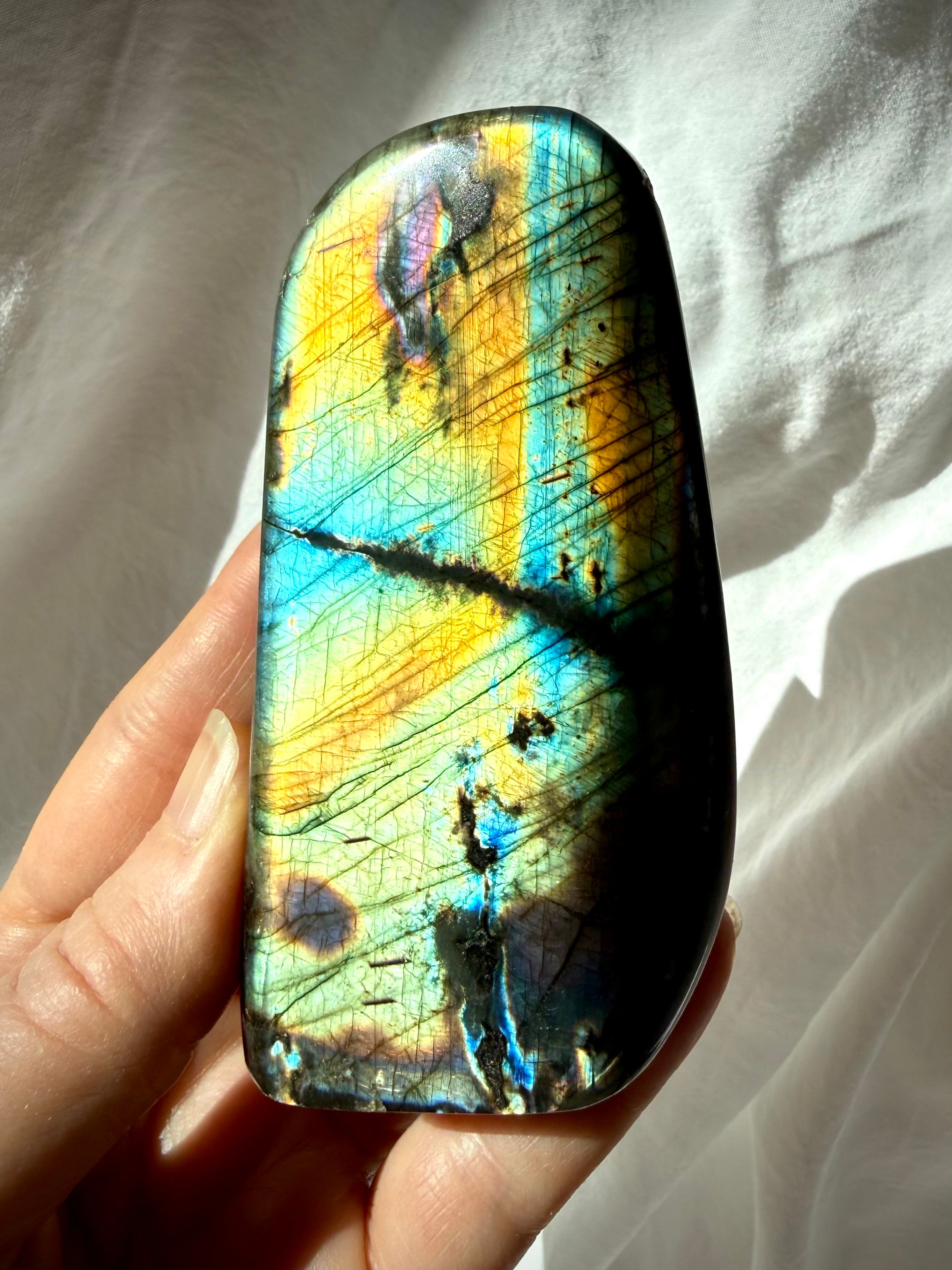 Rainbow Labradorite freeform held in hand, crystal for intuition, protection, transformation, and Third Eye Chakra work