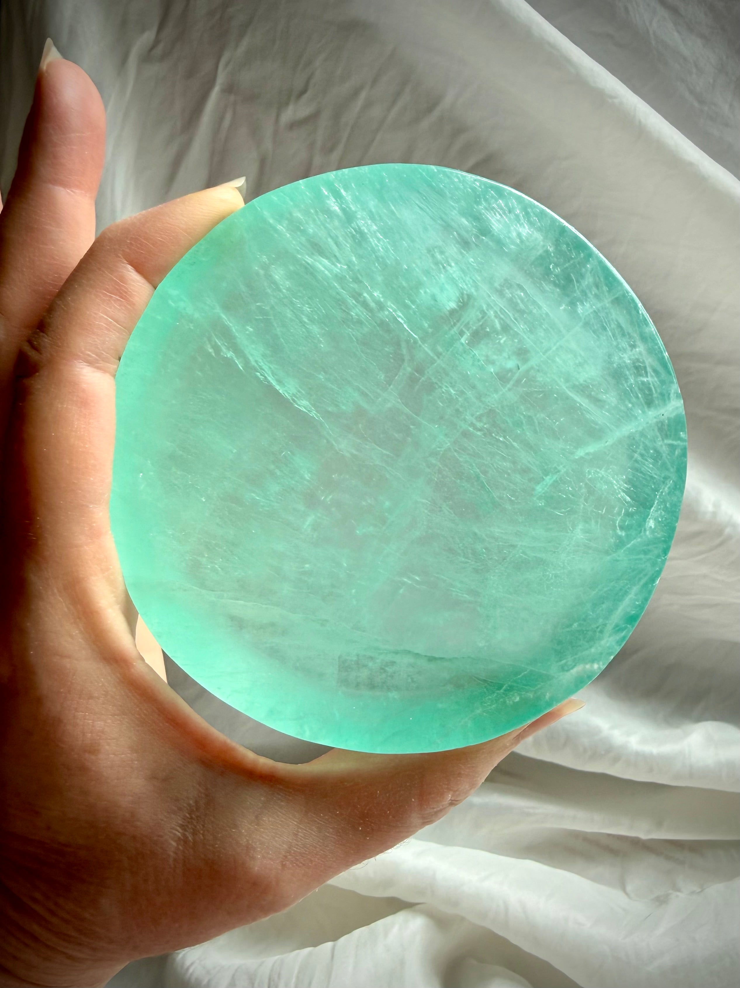 Green Fluorite crystal bowl held in hand showing translucent aqua-green color