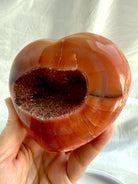 Opposite side of one of a kind Carnelian geode heart with polished red-orange patterns