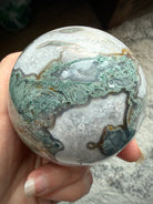 Moss Agate crystal sphere with stand featuring natural druzy texture and polished crystal surface