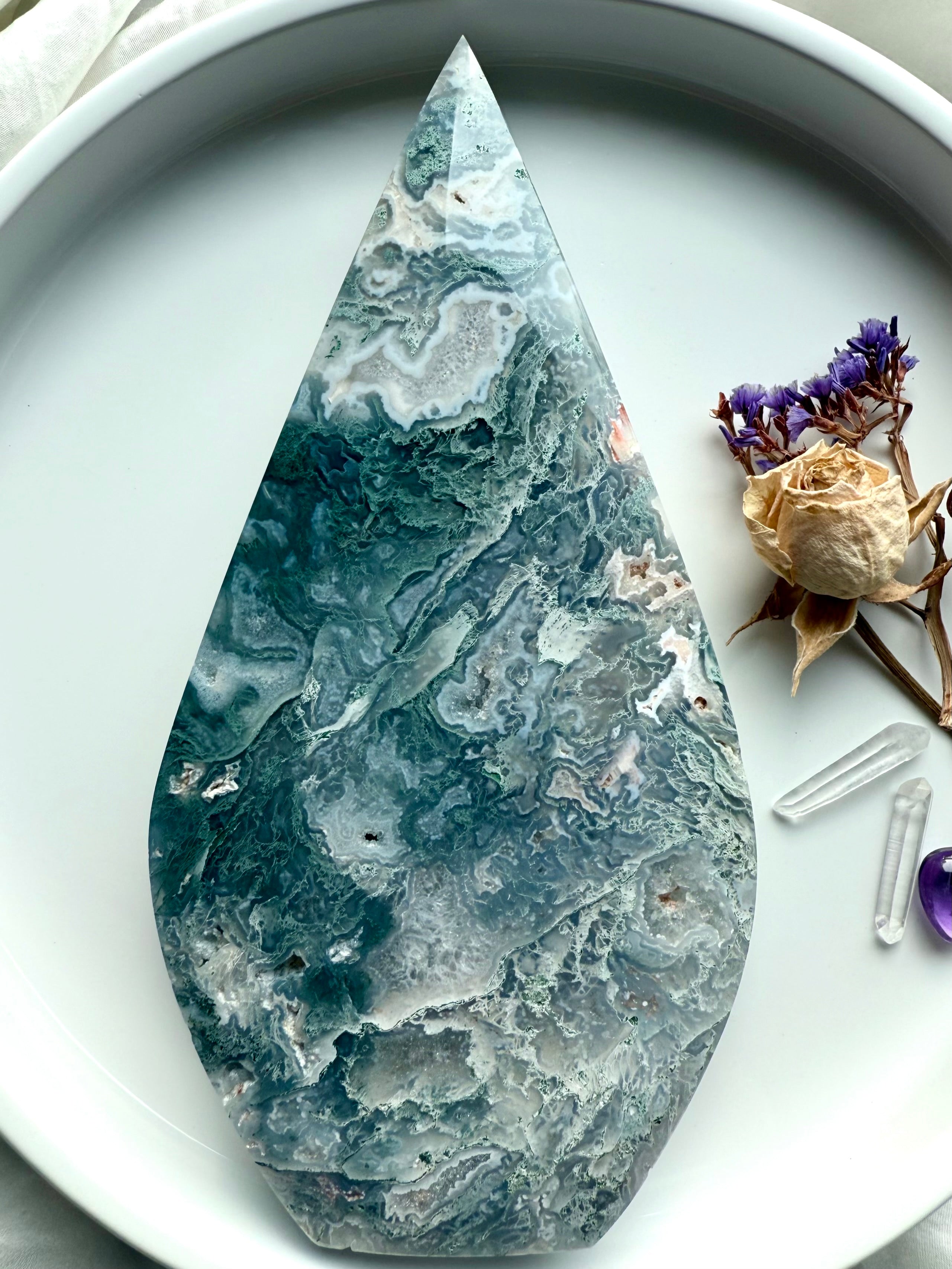 Moss agate flame crystal with icy teal blue-green hues and quartz druzy on altar display