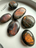 Peachy orange Labradorite palm stones with sunset flash and charcoal gray base