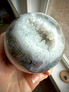 Moss Agate geode sphere with sparkling Quartz crystal cavern, luminous white Quartz and layered blue-gray chalcedony banding