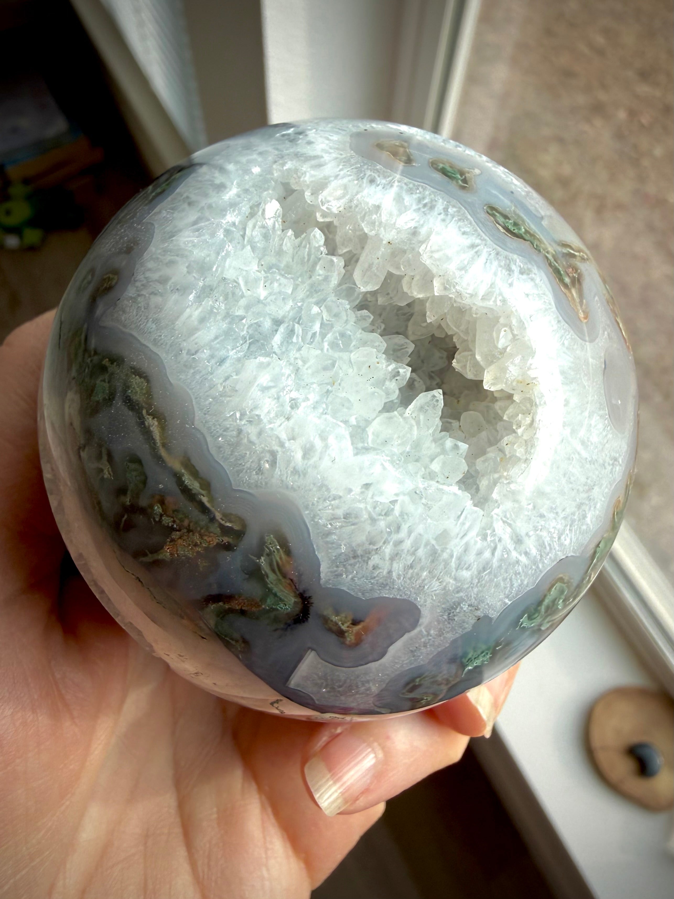 Moss Agate geode sphere with sparkling Quartz crystal cavern, luminous white Quartz and layered blue-gray chalcedony banding